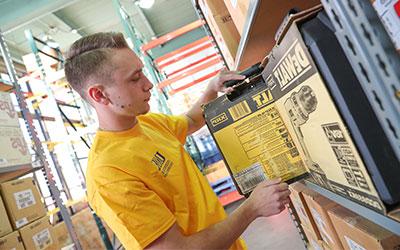 a student pulls an item off the shelf in the industrial distribution lab